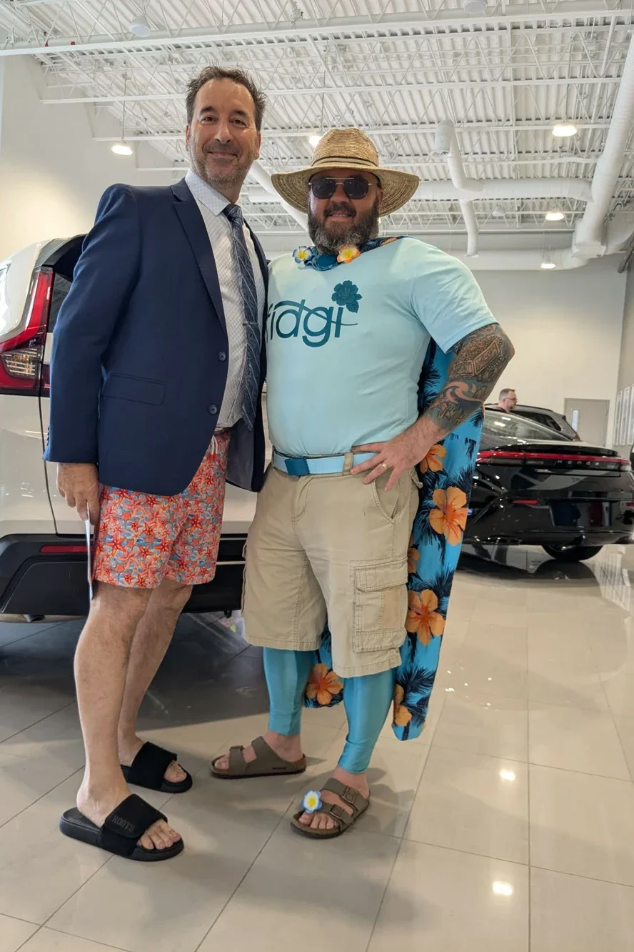 Two characters from the Fiji campaign posing in front of a white Honda SUV