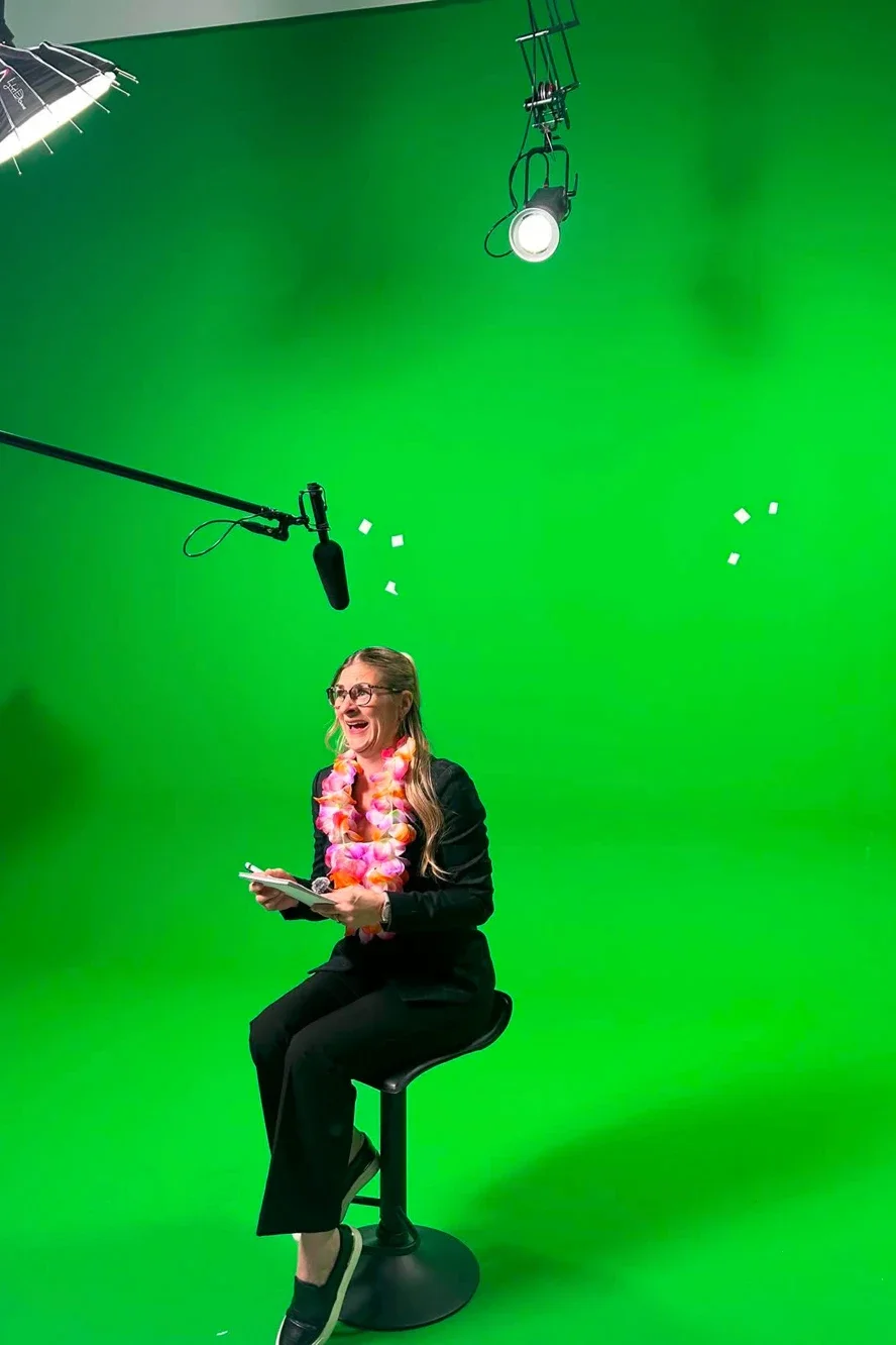 Animator on a stool in front of a green background in the studio for the Fidgi capsules