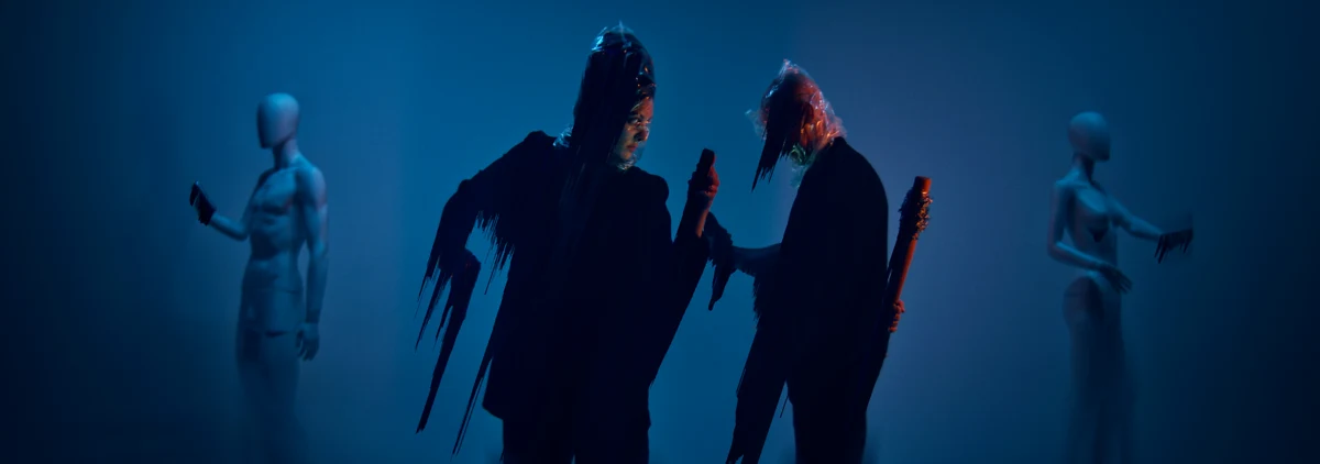 Image du vidéoclip Wicked Signal : deux figures encapuchonnées entourées de mannequins